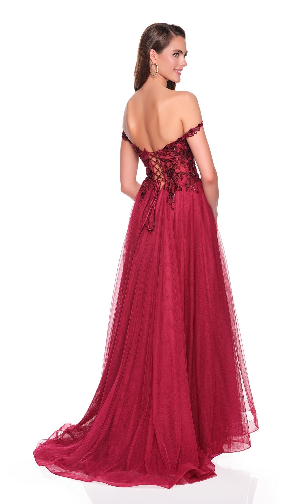 A woman stands against a white background in the Dave and Johnny 12808 long prom dress—burgundy, off-shoulder with an embroidered bodice, floral lace details, lace-up back, and a flowing tulle A-line skirt.